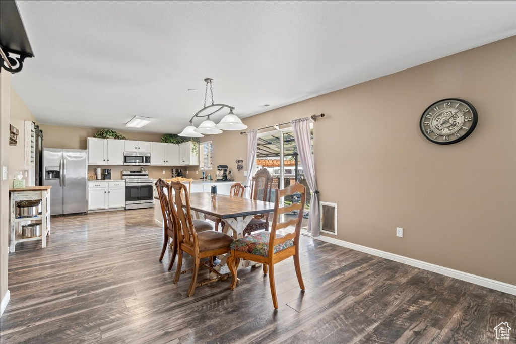 Dining space with dark wood-style floors and baseboards