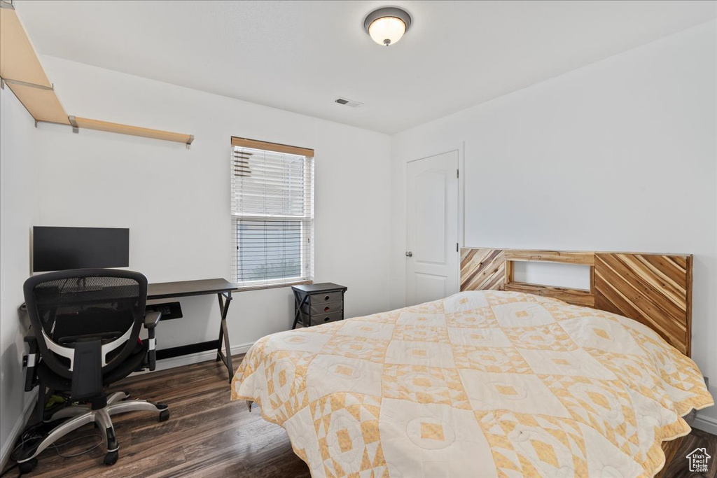 Bedroom featuring dark wood finished floors and a desk
