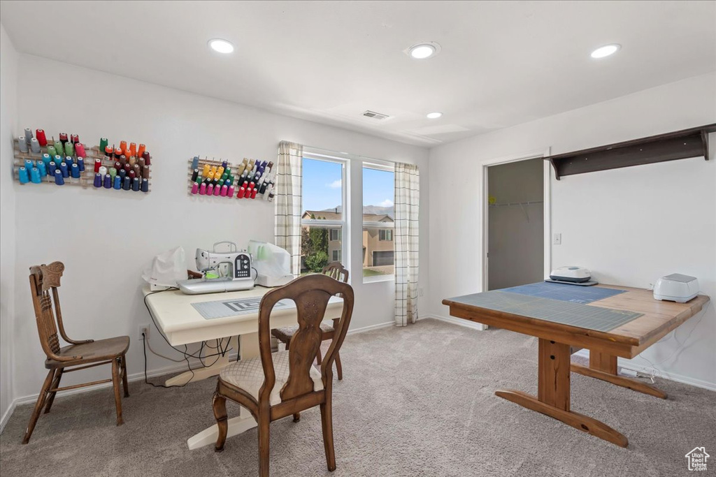 Carpeted dining area with a desk and recessed lighting