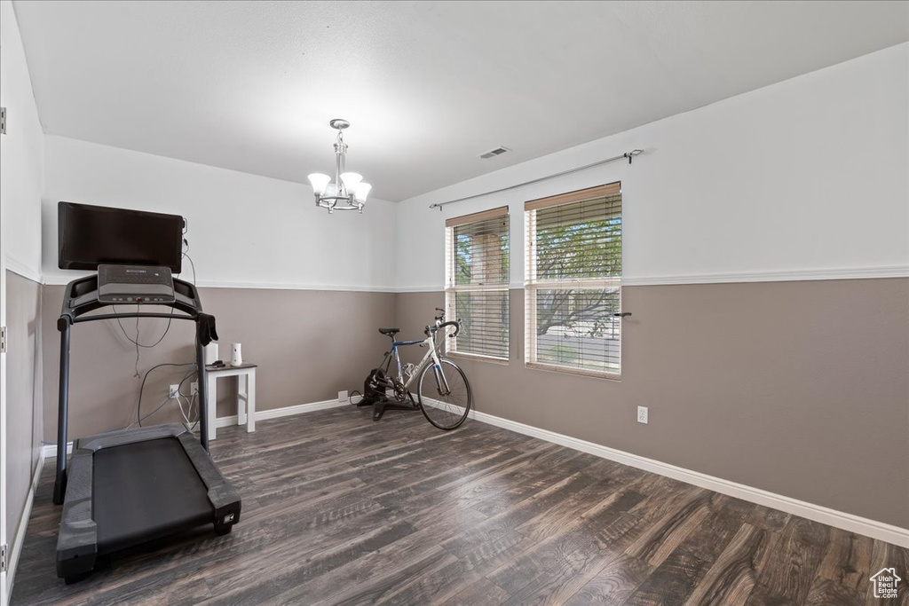 Exercise room featuring wood finished floors and a chandelier