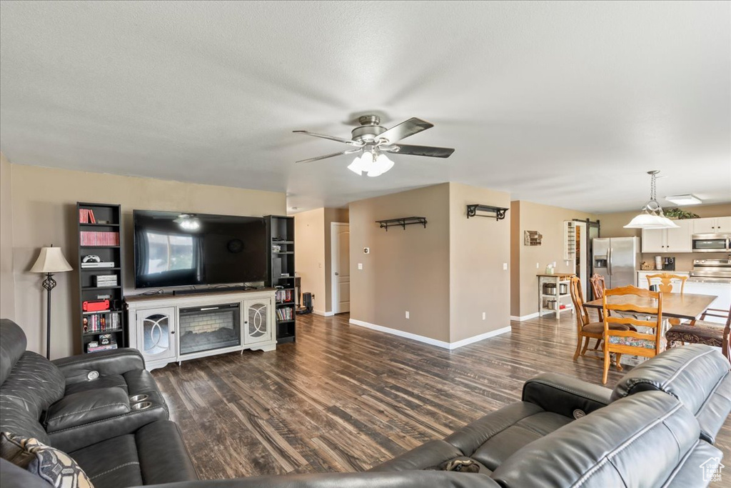 Living area featuring dark wood finished floors and ceiling fan