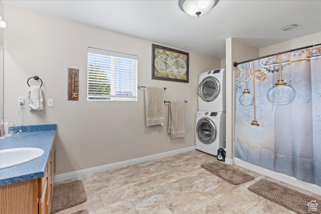 Full bathroom with stacked washer and clothes dryer, vanity, and a shower with shower curtain