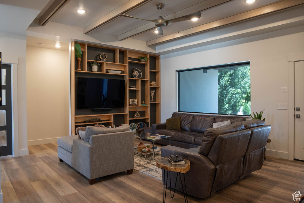 Living area with beamed ceiling, wood finished floors, and recessed lighting