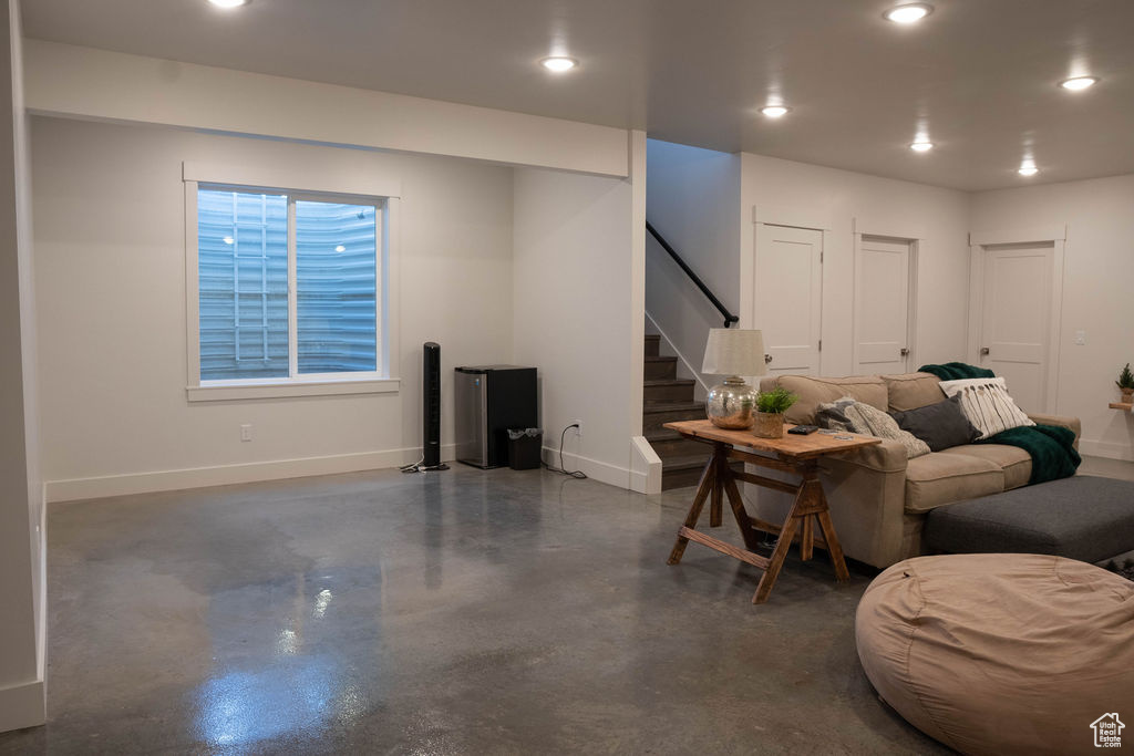 Living area featuring finished concrete floors, stairs, and recessed lighting