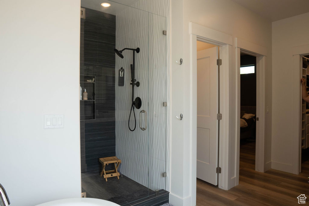 Bathroom featuring a shower stall and wood finished floors