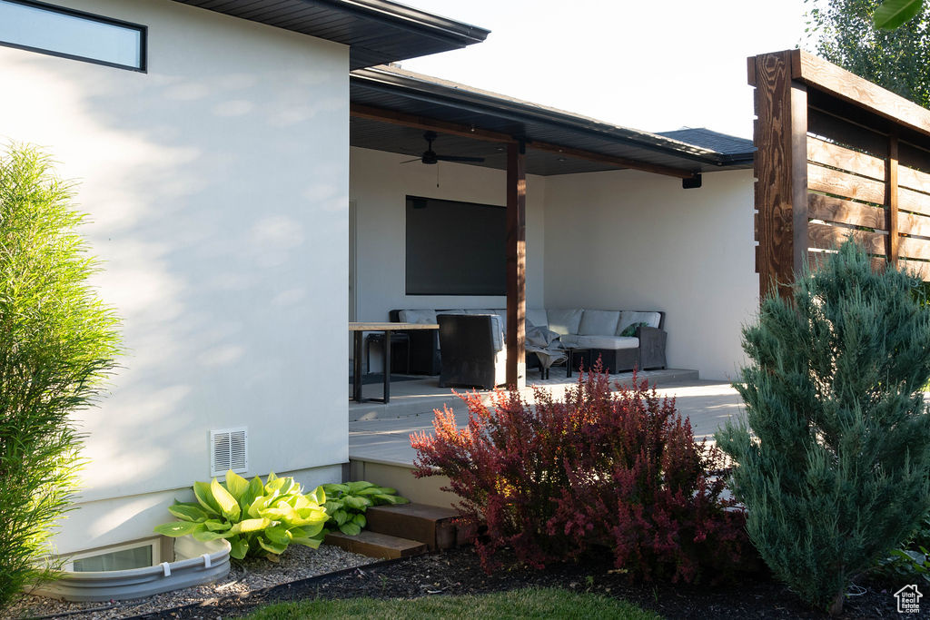 Doorway to property with ceiling fan, stucco siding, and an outdoor living space