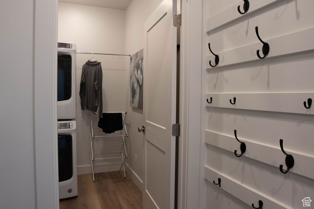 Laundry room featuring dark wood-style floors and estacked washer and dryer