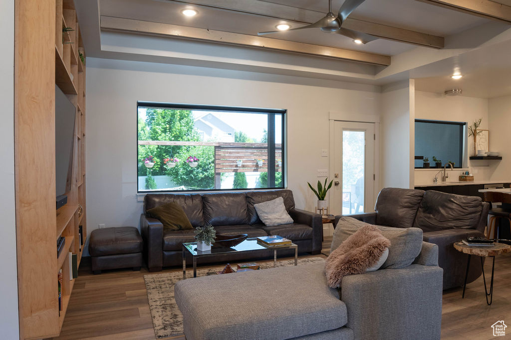Living room with wood finished floors, ceiling fan, beamed ceiling, and recessed lighting
