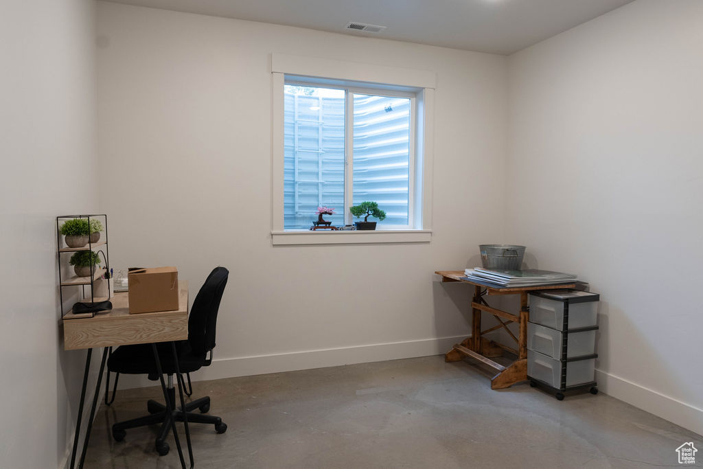 Office area with baseboards and concrete flooring