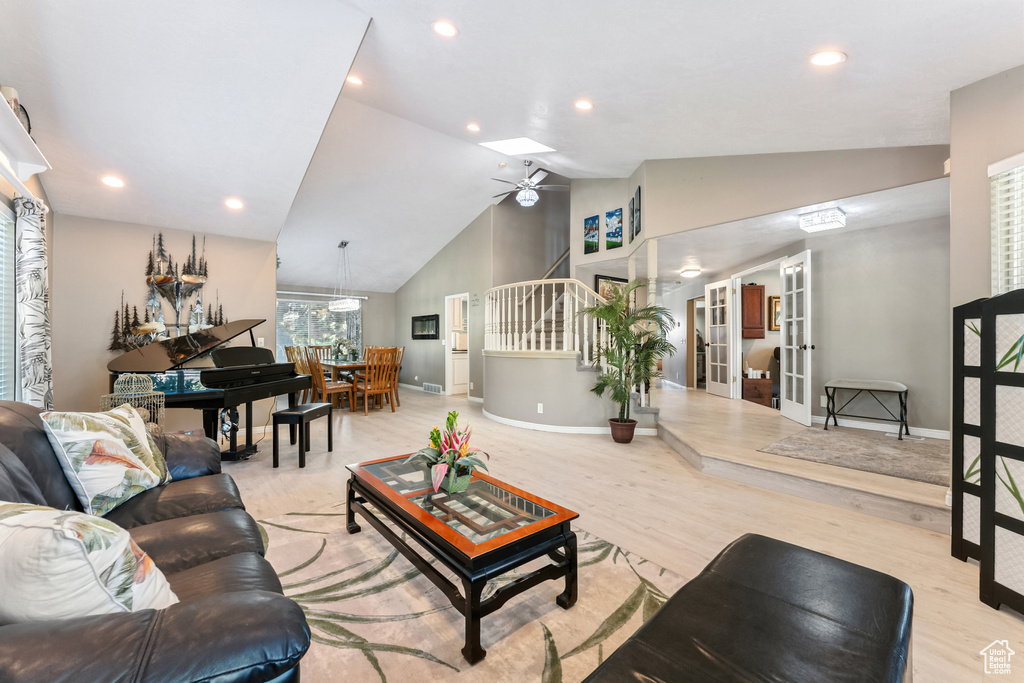Living room with ceiling fan, stairs, wood finished floors, french doors, and recessed lighting