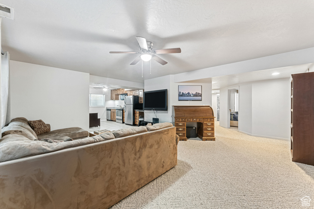 Living room featuring a ceiling fan and light carpet