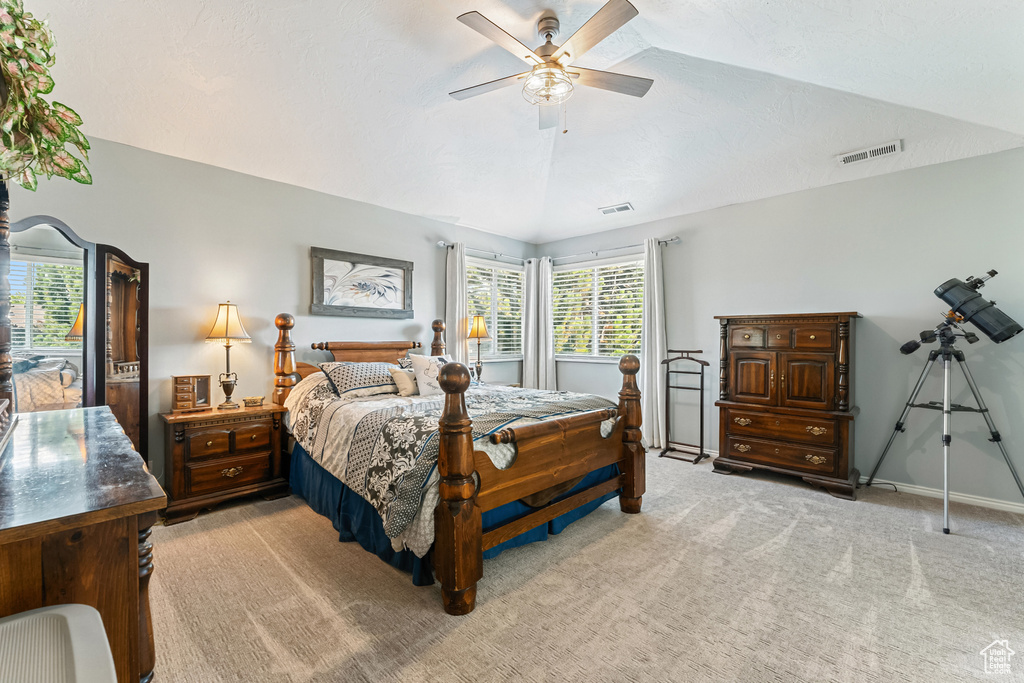 Bedroom featuring light carpet, lofted ceiling, and a ceiling fan
