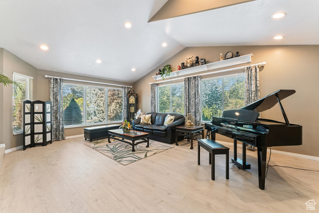 Living room with vaulted ceiling, recessed lighting, and wood finished floors