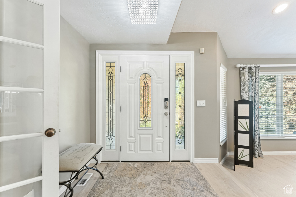 Foyer entrance with wood finished floors and baseboards