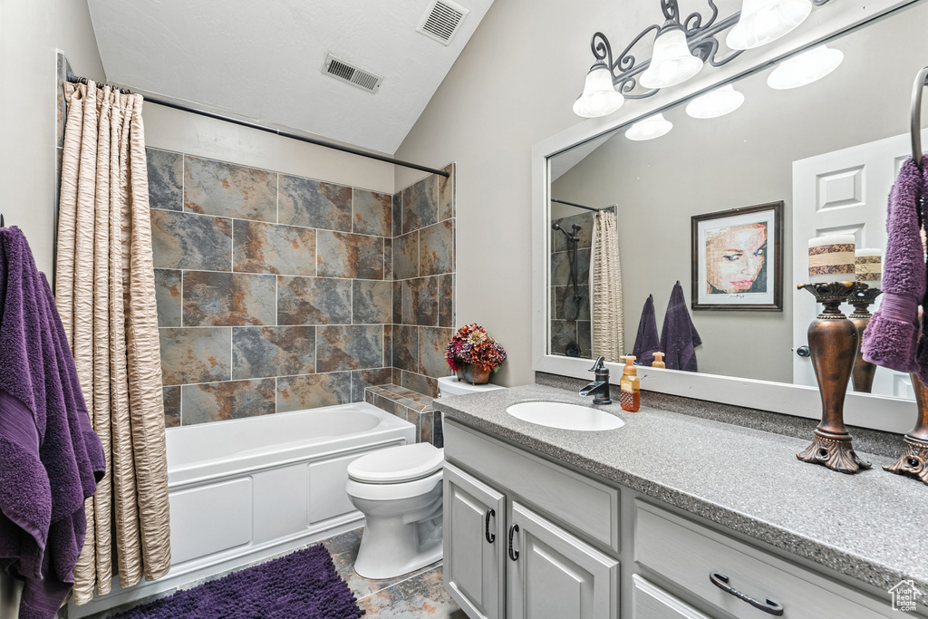 Full bath featuring vanity, shower / bath combination with curtain, and lofted ceiling