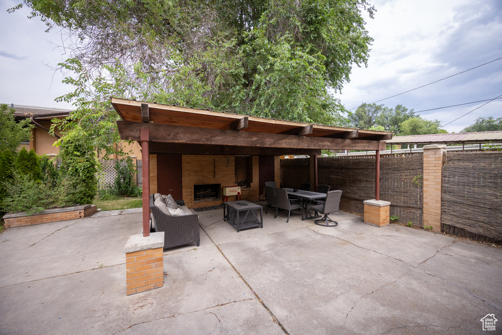 Fenced backyard with a patio, an outdoor living space with a fireplace, and outdoor dining space