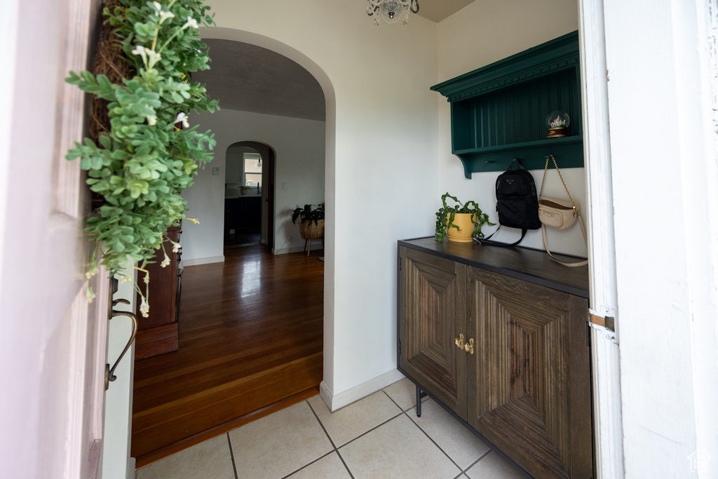 Hall featuring arched walkways and light tile patterned flooring