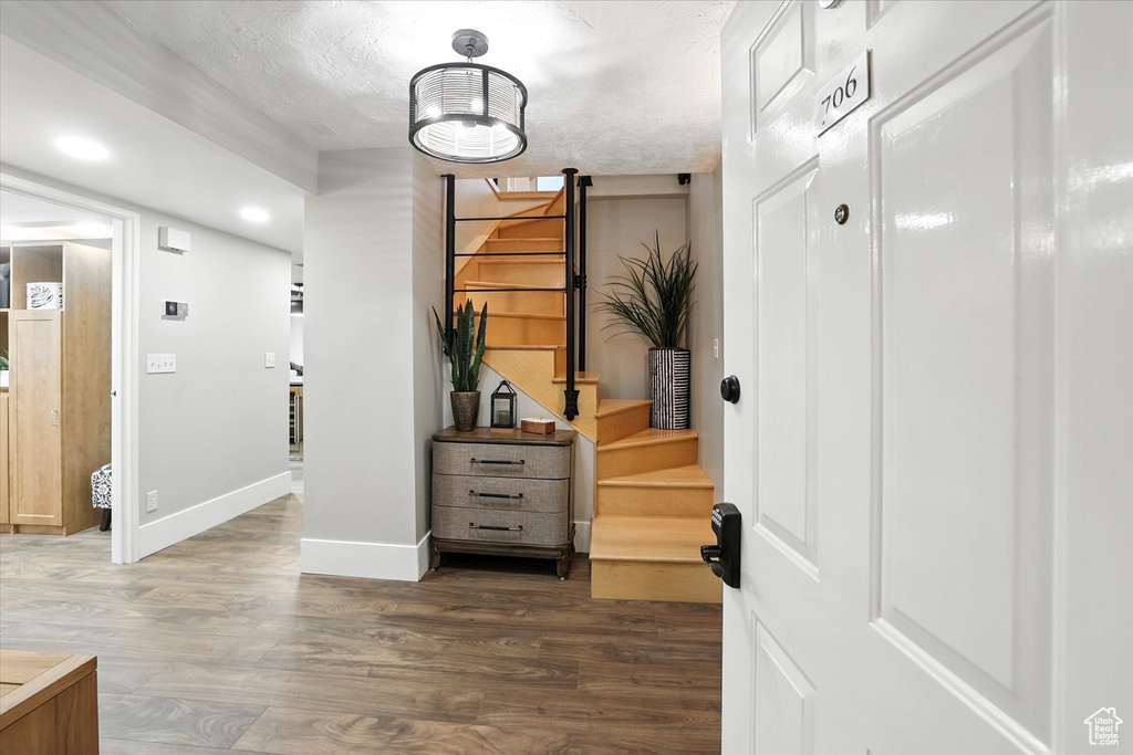 Hallway featuring stairs, wood finished floors, and recessed lighting