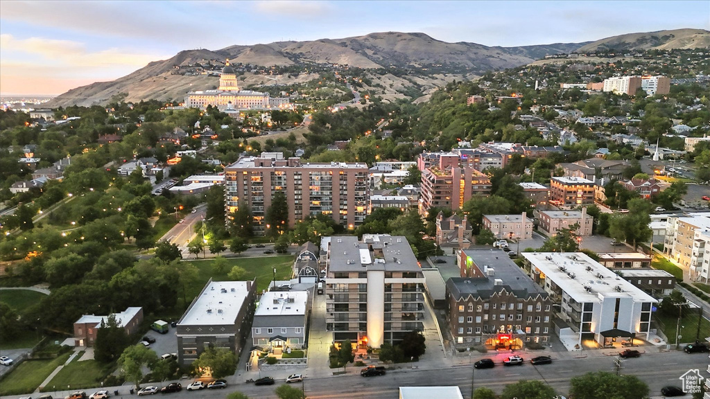 Aerial view of property and surrounding area with a mountain backdrop and nearby urban area