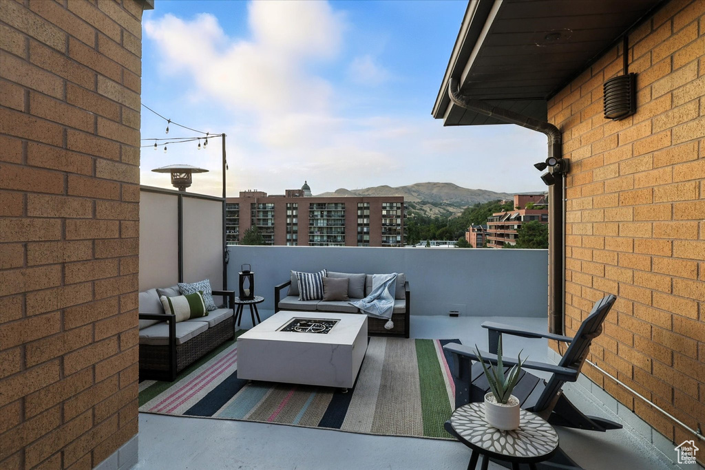 Balcony featuring an outdoor living space with a fire pit and a mountain view