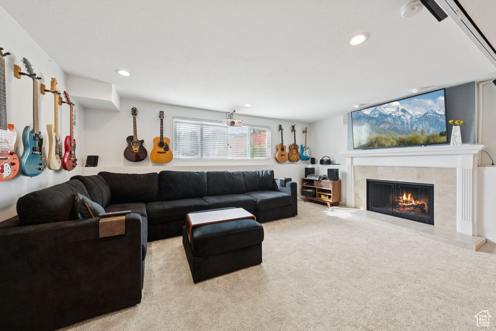 Carpeted living area featuring a tile fireplace and recessed lighting