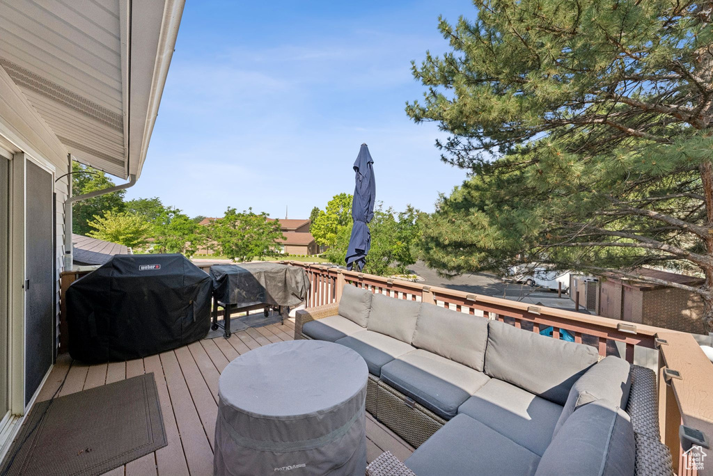 Wooden terrace with an outdoor hangout area and area for grilling