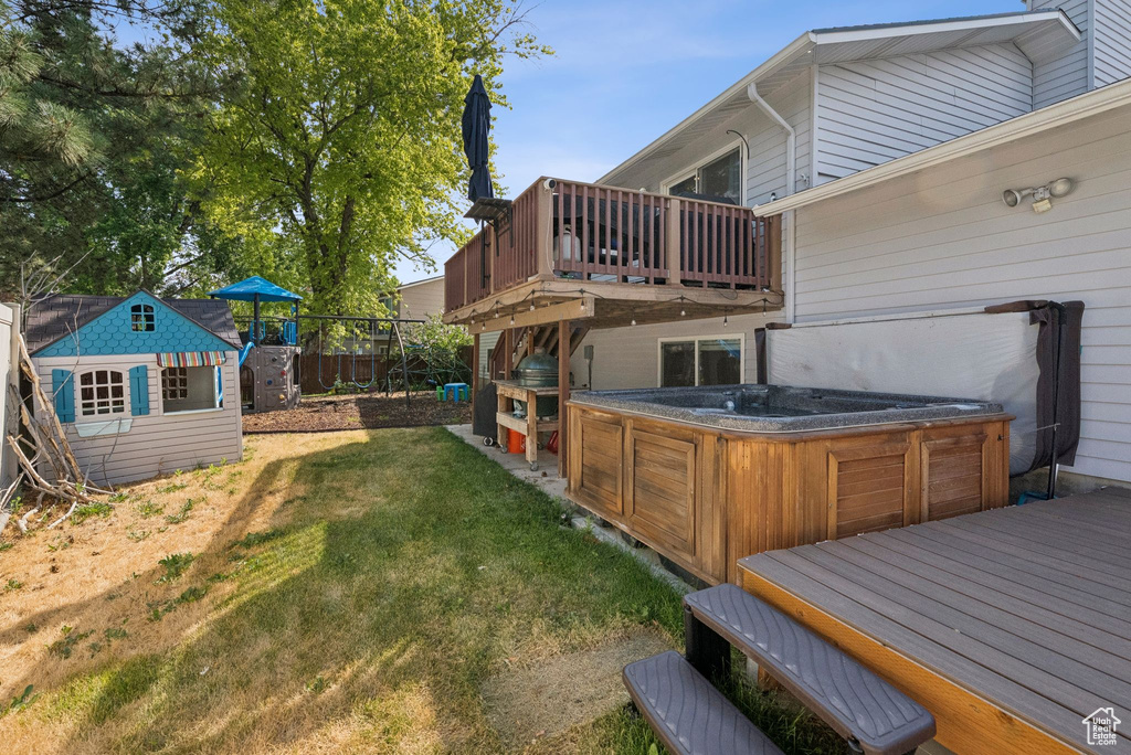 View of yard featuring a hot tub and a deck