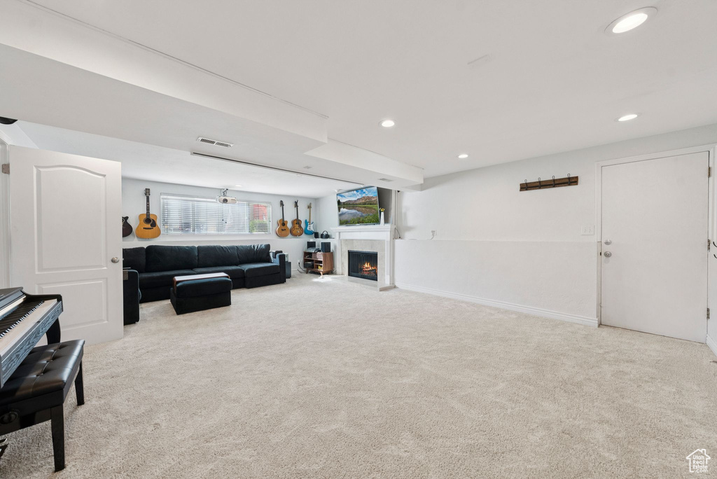 Carpeted living area with recessed lighting and a tile fireplace
