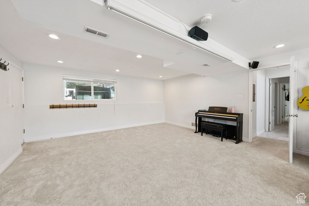 Sitting room with light colored carpet and recessed lighting