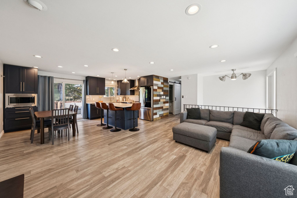 Living area with light wood-style flooring and recessed lighting