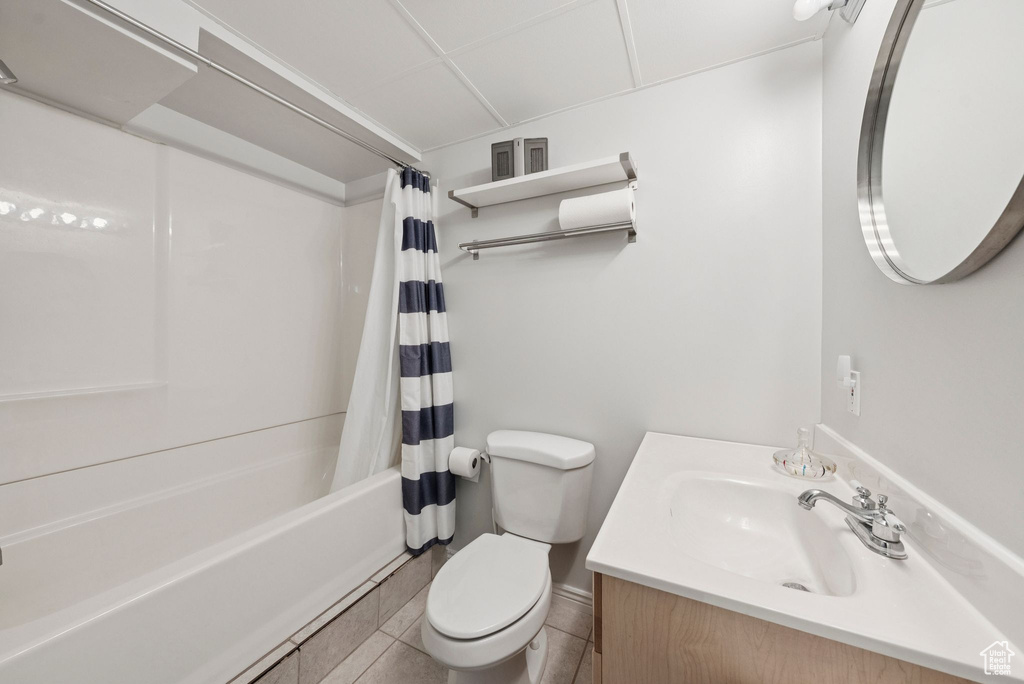 Bathroom featuring shower / bath combo with shower curtain, vanity, and tile patterned flooring