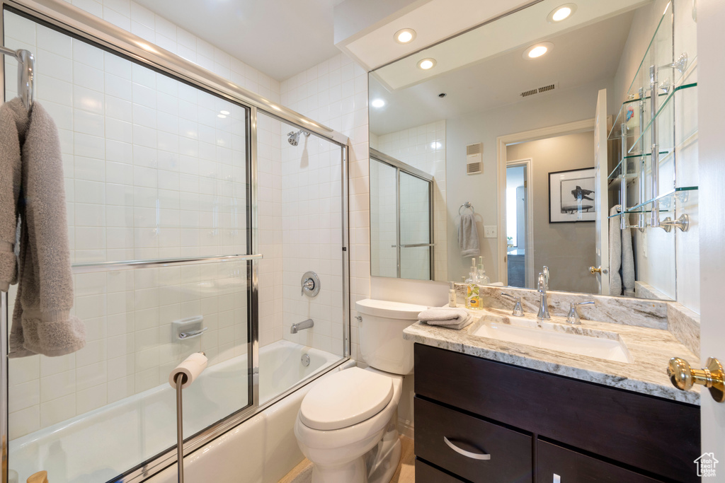 Bathroom with recessed lighting, shower / bath combination with glass door, and vanity
