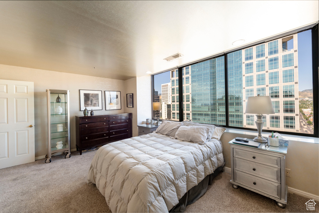 Bedroom with carpet and multiple windows