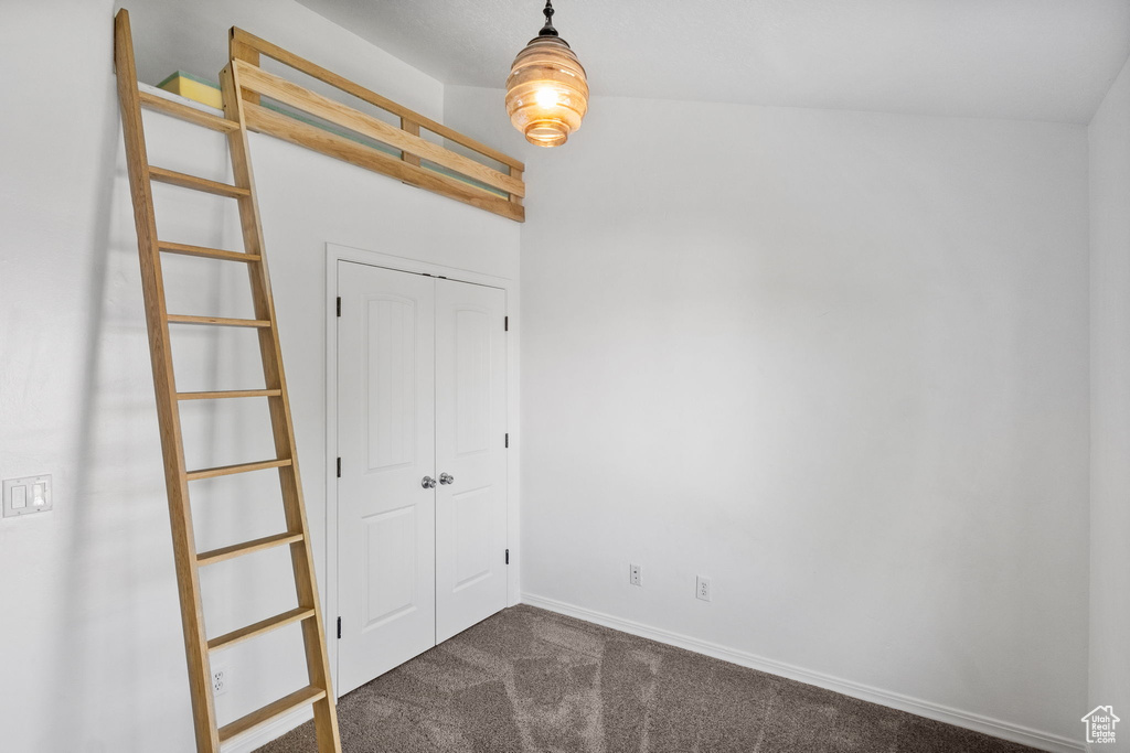 Unfurnished bedroom with dark carpet and a closet