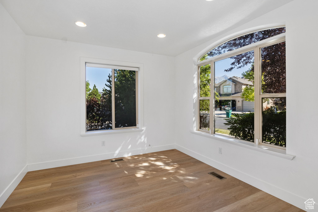 Spare room with wood finished floors and recessed lighting