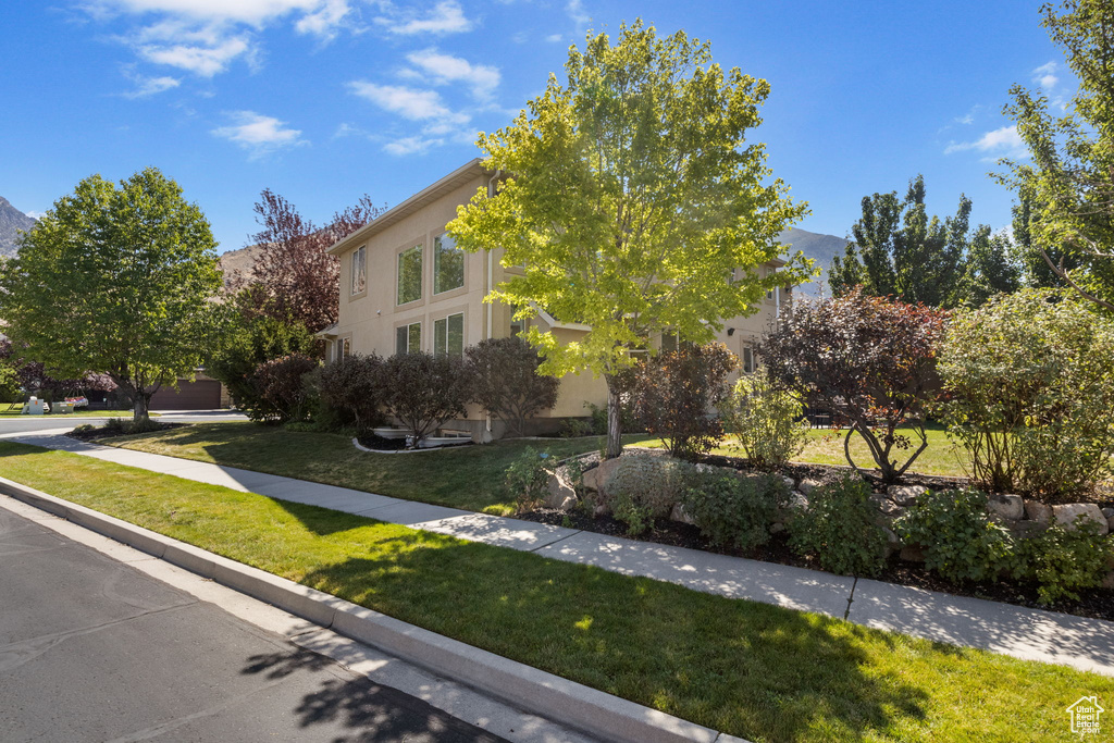 View of front of property with a front yard and stucco siding