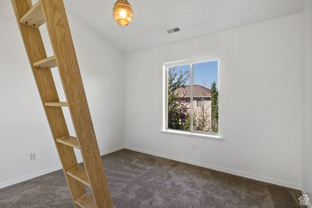 Spare room featuring dark carpet
