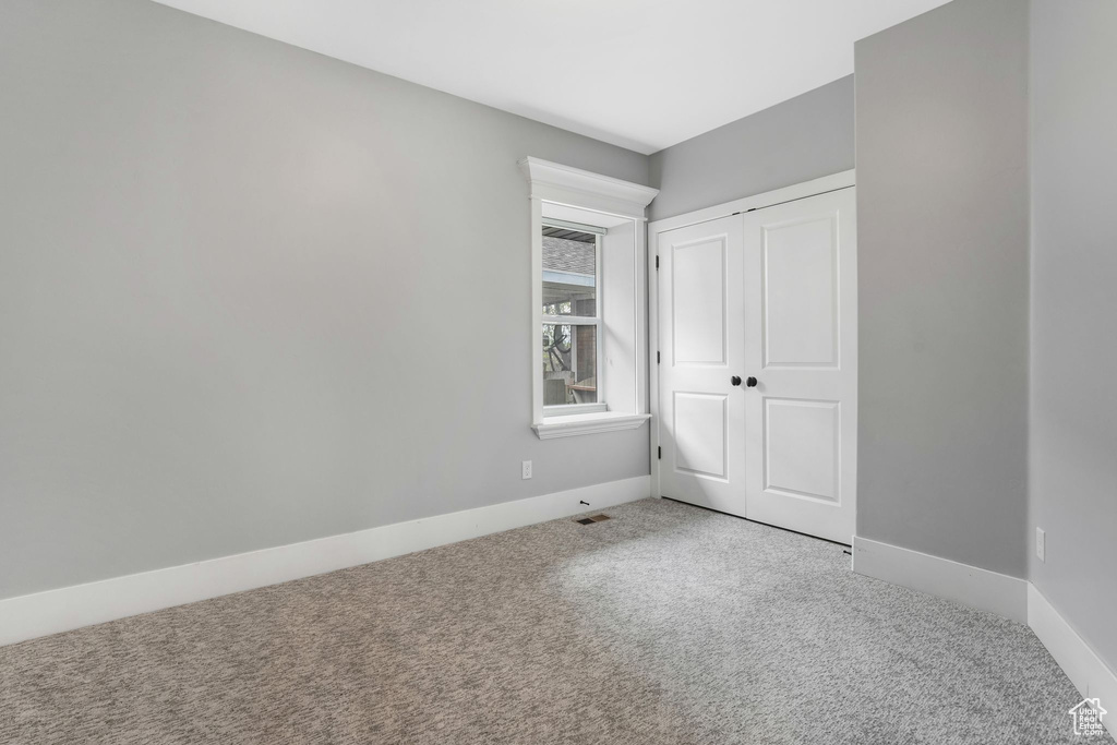 Unfurnished bedroom with carpet and a closet