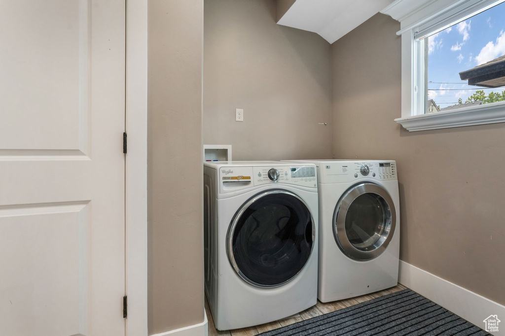 Washroom with washer and clothes dryer and baseboards