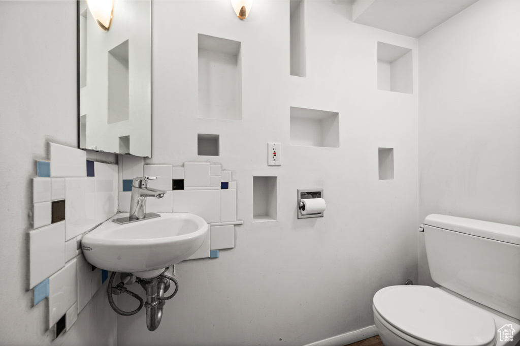 Half bathroom with toilet and baseboards