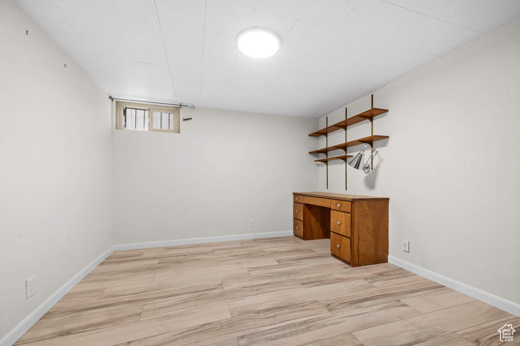 Below grade area with light wood-type flooring and baseboards