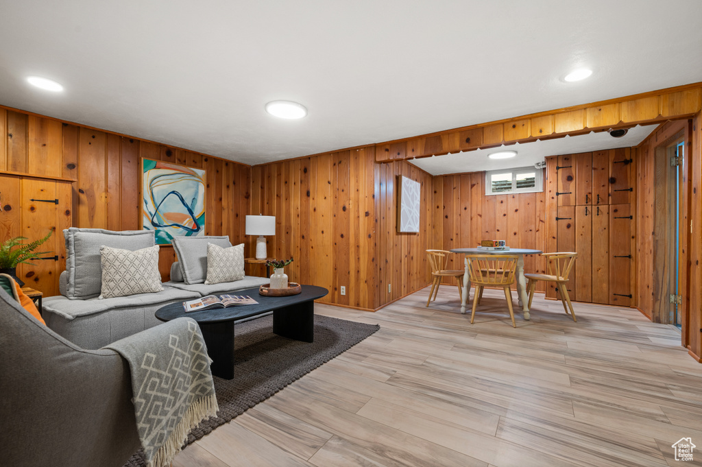 Living area with light wood-type flooring and wooden walls