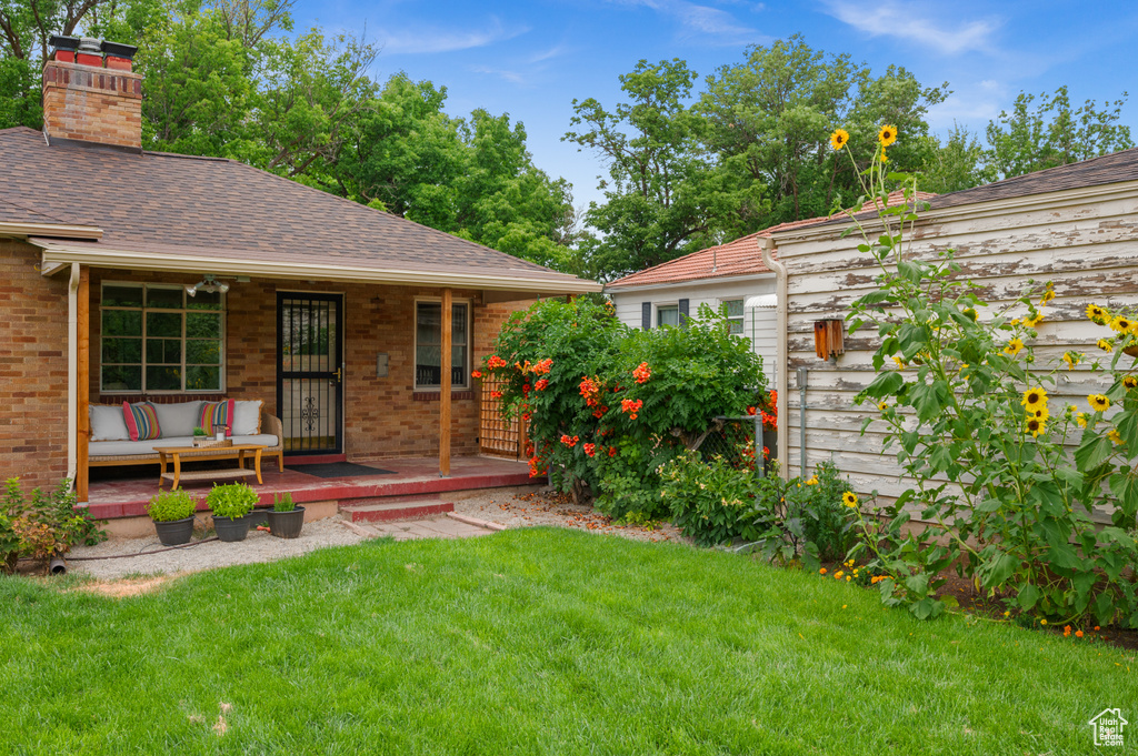 View of green lawn featuring a porch and outdoor lounge area