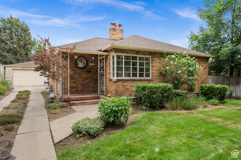 Bungalow-style home with a chimney, brick siding, a shingled roof, a garage, and concrete driveway