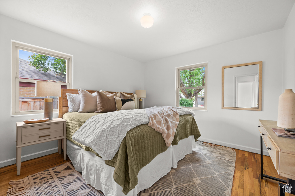 Bedroom featuring dark wood-style floors and baseboards