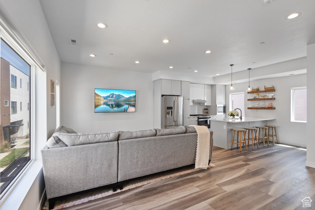 Living room with light wood finished floors and recessed lighting