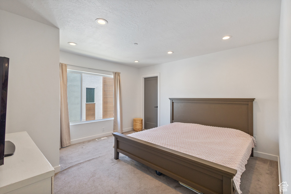 Bedroom with light colored carpet and recessed lighting