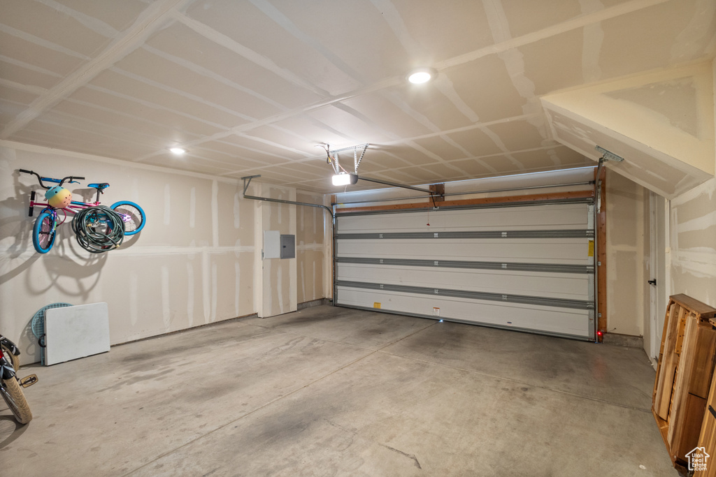 Garage featuring electric panel and recessed lighting