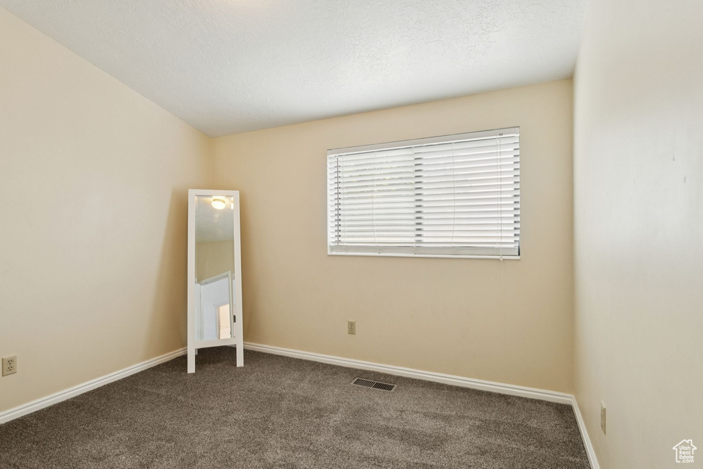 Empty room featuring carpet floors and baseboards
