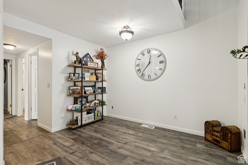 Empty room featuring dark wood finished floors and a textured ceiling